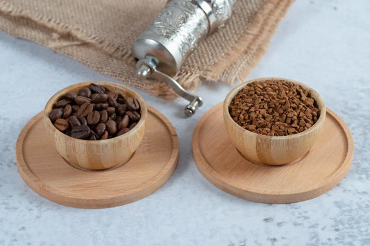 two cups on counter, one with whole coffee beans, the other with ground coffee beans